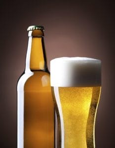 Gluten-free beer glass and bottle on a brown  background.