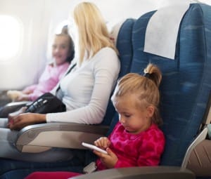 Little girl using smart phone in airplane.