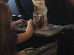 Girl eating trail mix containing nuts on flight