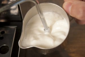 Barista froths milk. Starbucks: Sip or Eat at Your Own Risk with Food Allergies