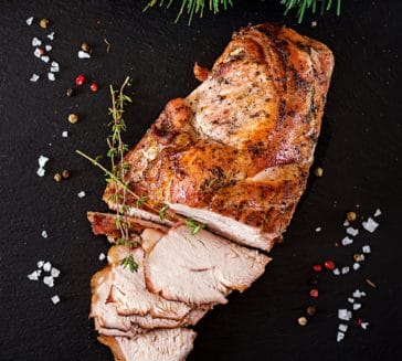 Roasted sliced Christmas turkey on dark rustic background. Top view. Festival food.