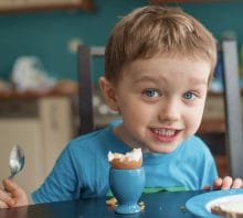 Child eating an egg with toast. Xolair looks may well become the first “anti-IgE” biologic drug to treat multiple food allergies. 