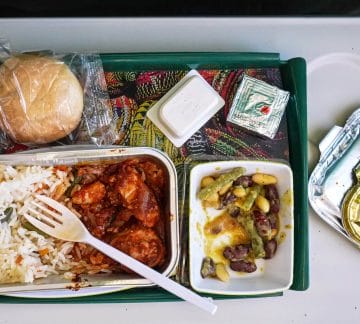 Airplane food, rice and chicken meat with beans salad, on tray table