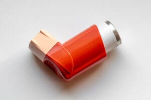 Asthma inhaler closeup on a white table.